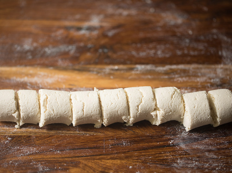 kneaded chenna ball shaped into a log and cut into equal pieces for making chom chom. 