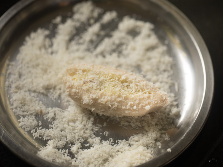 rolling stuffed cham cham on desiccated coconut. 