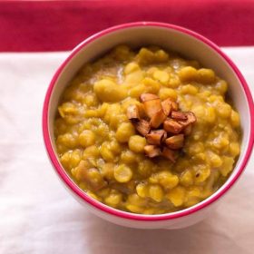 cholar dal in a bowl topped with fried coconut