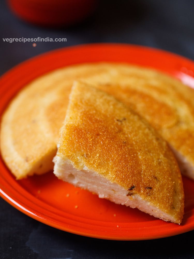 dibba rotti cut into wedges and served on a red colored plate. 
