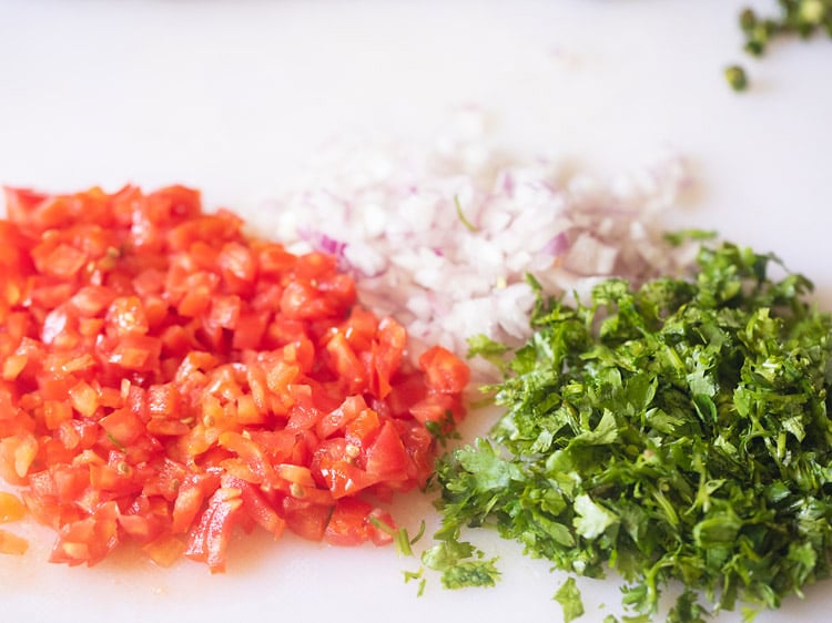 chopping onion, tomato, green chilli and coriander