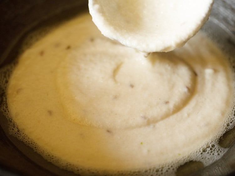 adding batter with a ladle in the pan. 