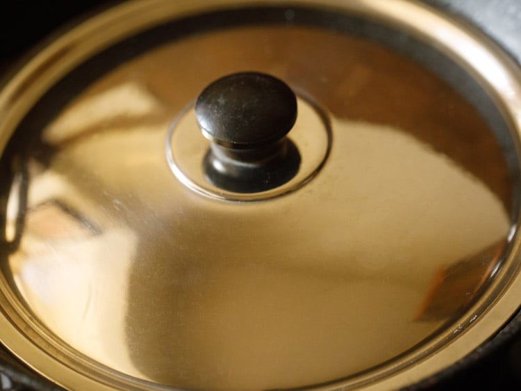 cooking dibba rotti in covered pan. 