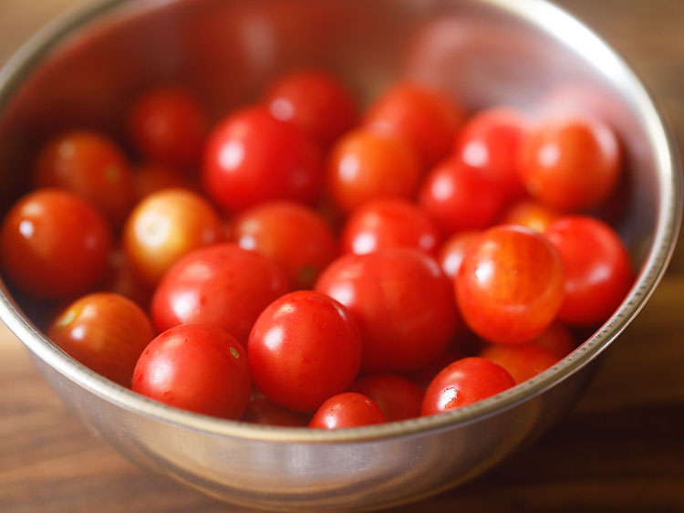 rinsing cherry tomatoes. draining them and allowing the water on them to dry naturally.