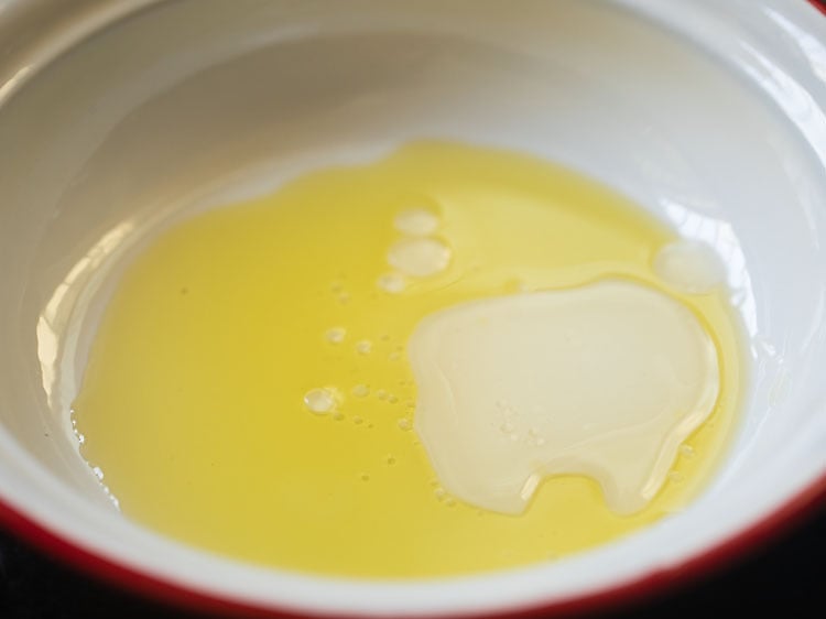 mezclar aceite de oliva virgen extra y vinagre de sidra de manzana en un tazón para hacer el aderezo. 