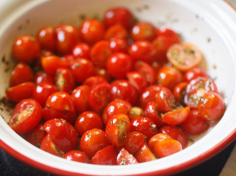 tossing and mixing the cherry tomatoes with the dressing. 