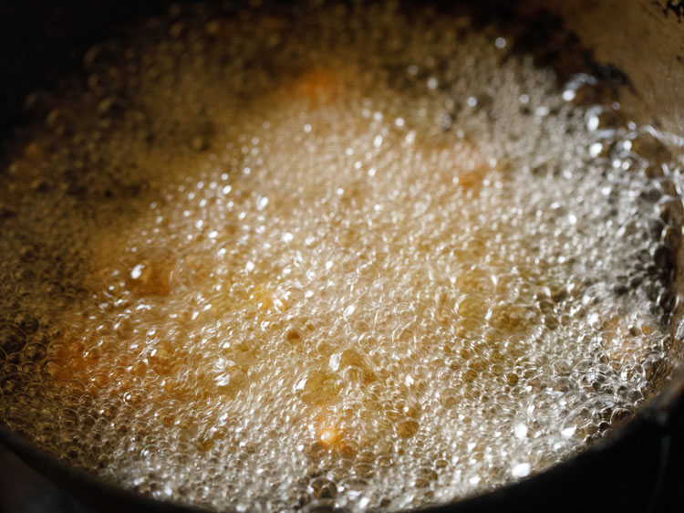 placing batter coated cauliflower florets in hot oil for frying