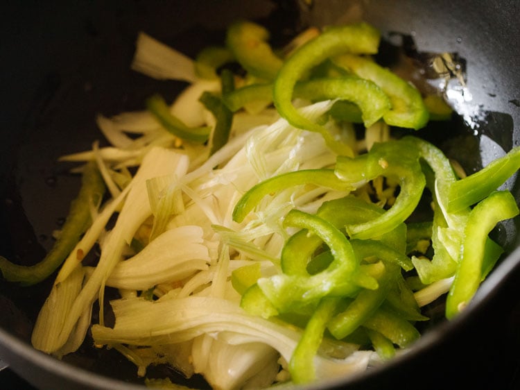 sliced spring onions and capsicum added in the wok