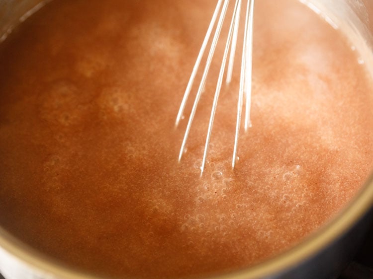stirring ragi mixture at intervals with a wired whisk