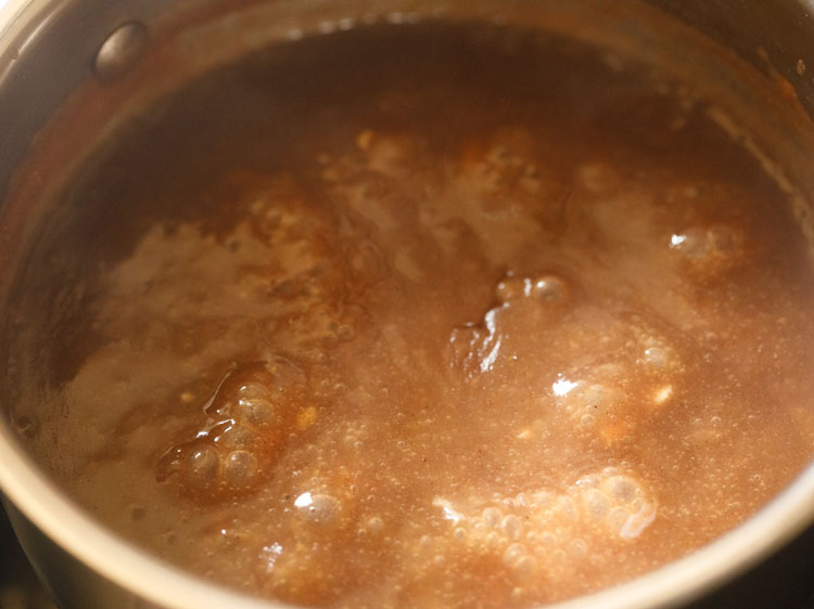 mixing cardamom powder and chopped cashews in the ragi malt.