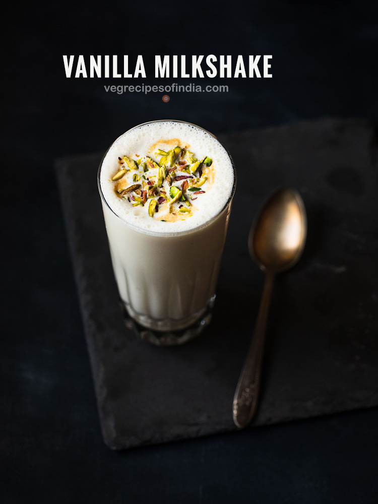 vanilla milkshake served in a glass. topped with chopped pistachios.