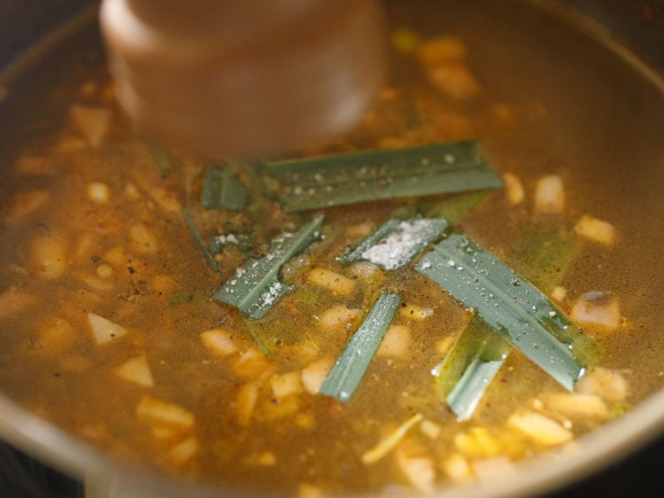 crushing black pepper in the lemon coriander soup mixture with a pepper mill.