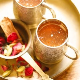 kashmiri kahwa served in two silver cups in a round brass plate