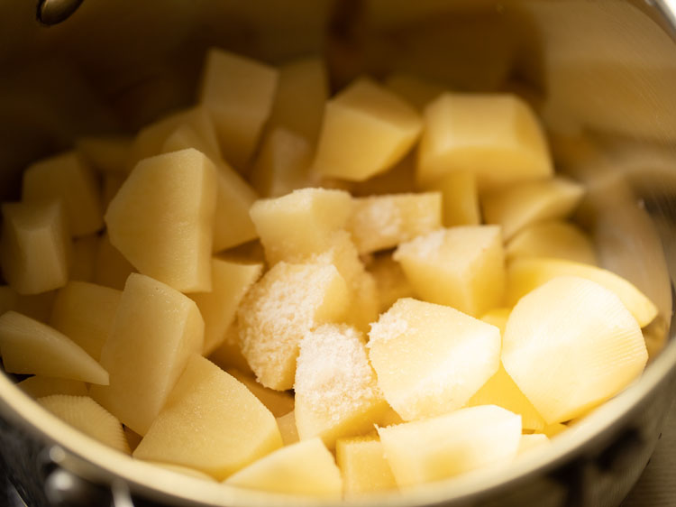 chopped potatoes and salt placed in a pan.