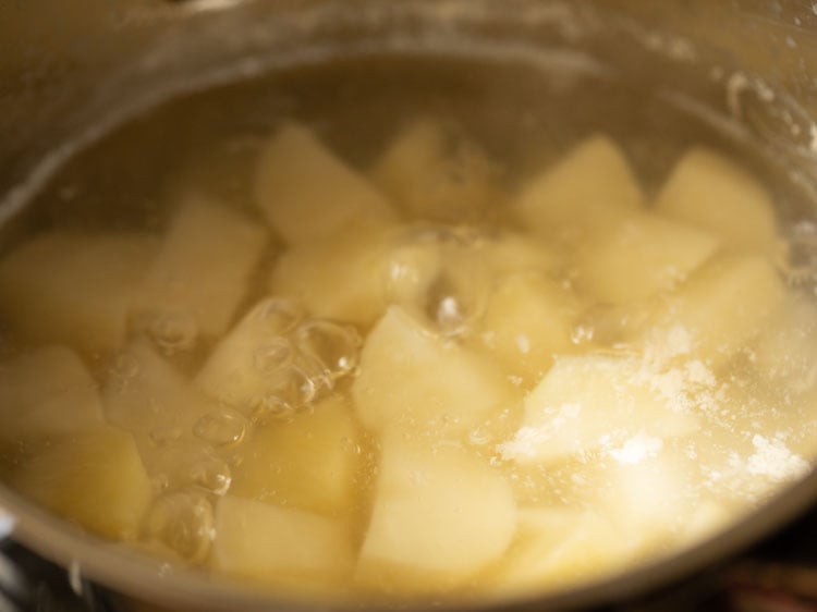 boiling and checking potatoes at intervals.