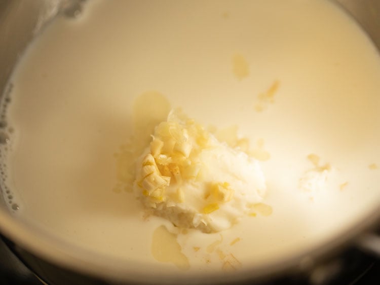ajo finamente picado agregado a la mezcla de leche y mantequilla en la sartén