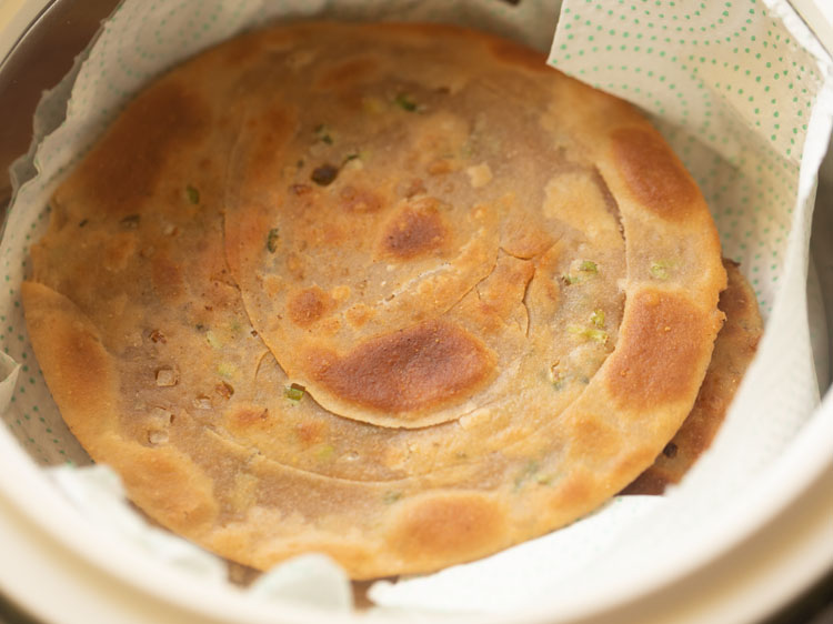 draining green onion pancakes on paper towels.