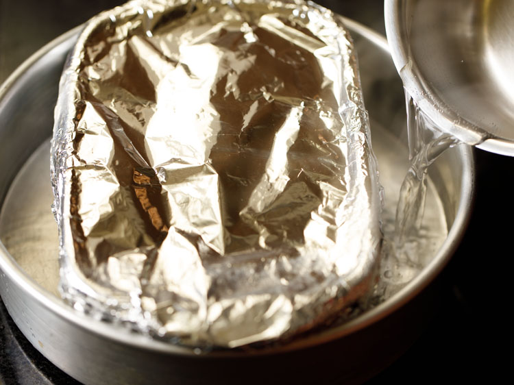 pouring hot water to make bain marie for making dulce de leche in the oven. 