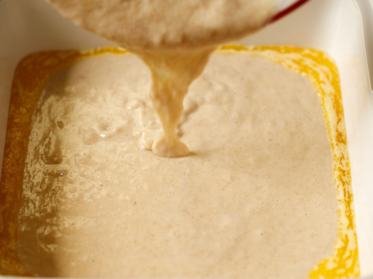 cobbler batter being poured over the butter.