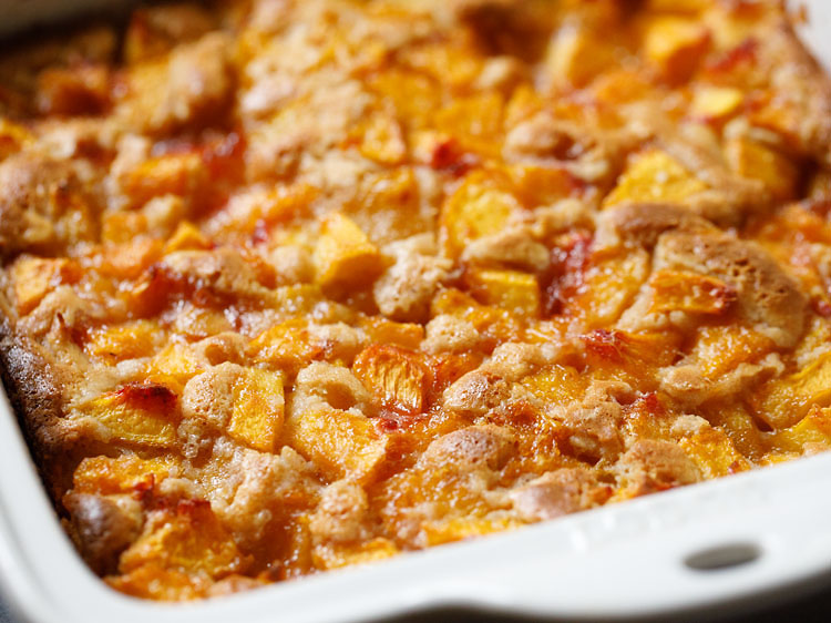 baked peach cobbler is golden on top with slightly darker edges.