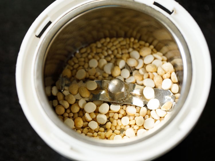 roasted urad dal and roasted chana dal added to a grinder jar.  