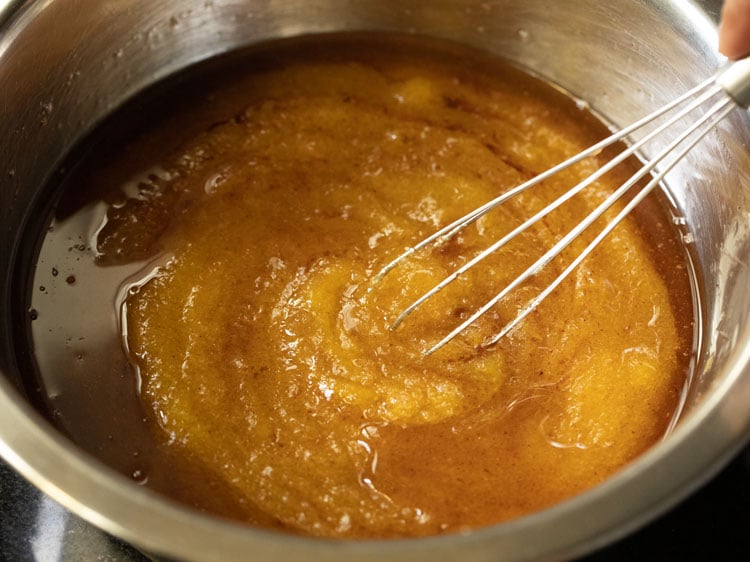 whisking together the wet ingredients for making pumpkin bread.