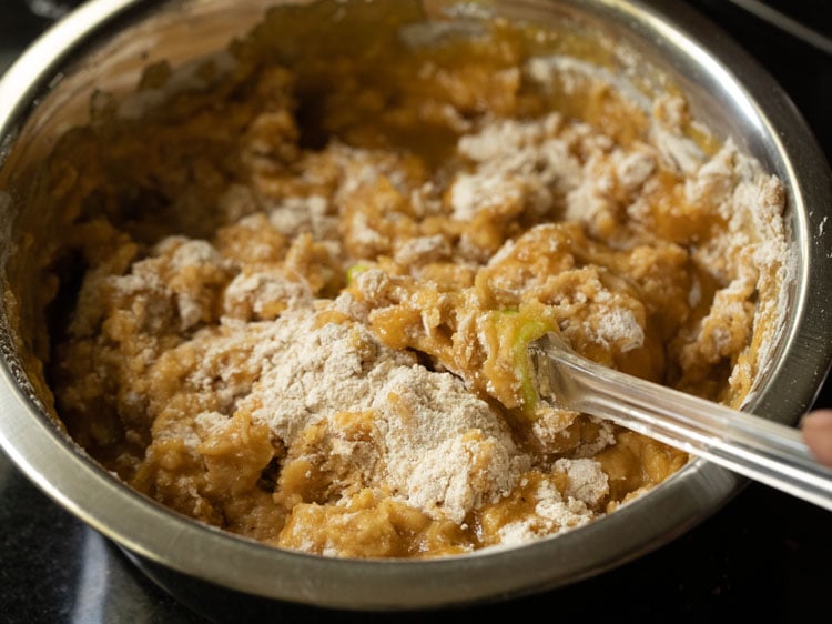 folding the dry ingredients into the wet for making pumpkin bread.