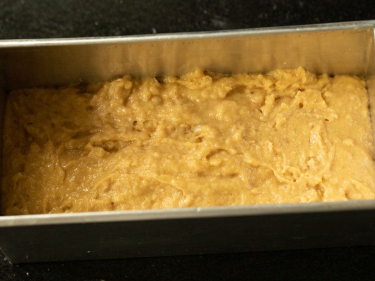 pumpkin bread batter in a loaf tin before baking. 