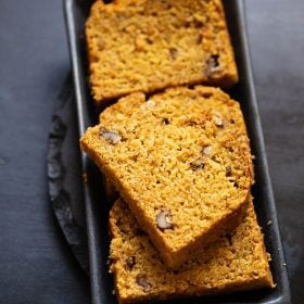 pumpkin bread slices on a black tray.