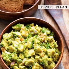 avocado salad in a wooden bowl with a wooden spoon by side with text layovers.