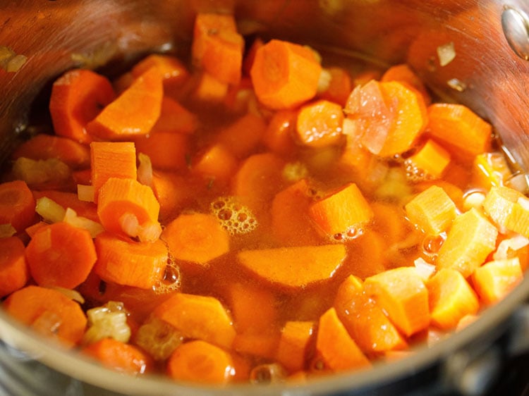 stirring all the contents of the carrot soup