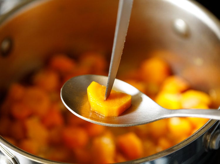 testing doneness of a cooked carrot cube