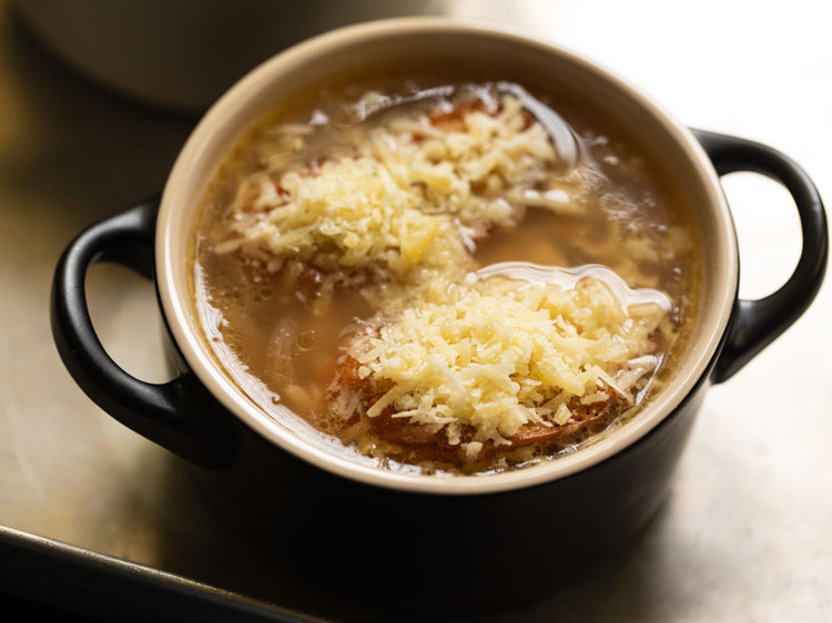 baguette slices topped with grated gruyere cheese to make french onion soup.