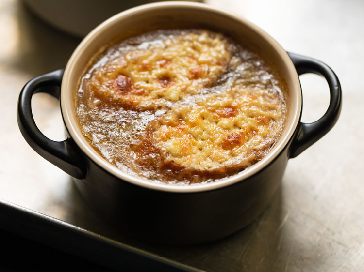 french onion soup bowls removed from the oven with the cheese melted and golden.