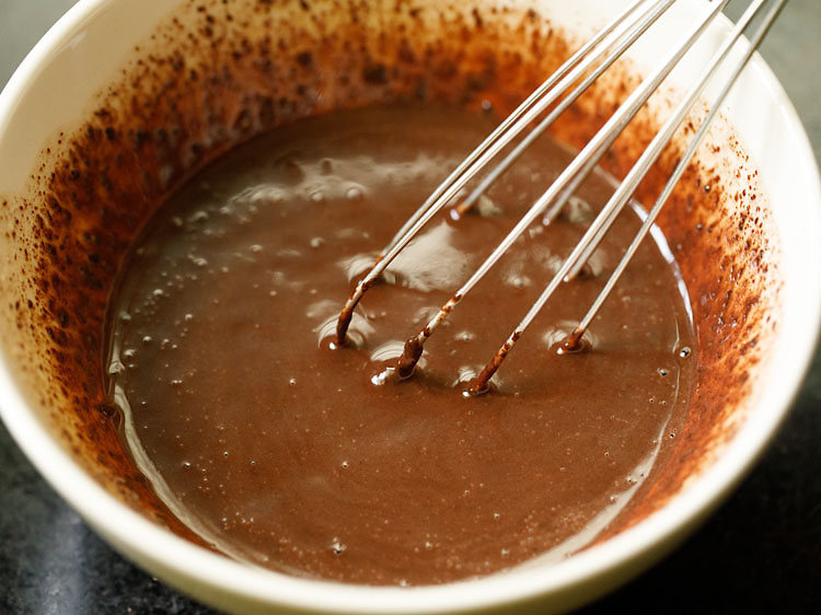 mixing chopped chocolate and milk with a wired whisk