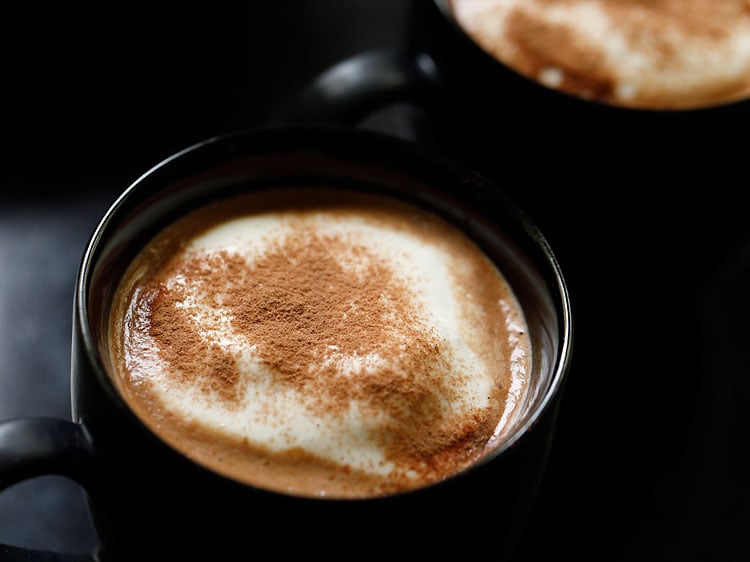 sprinkling cocoa powder on top of the cream