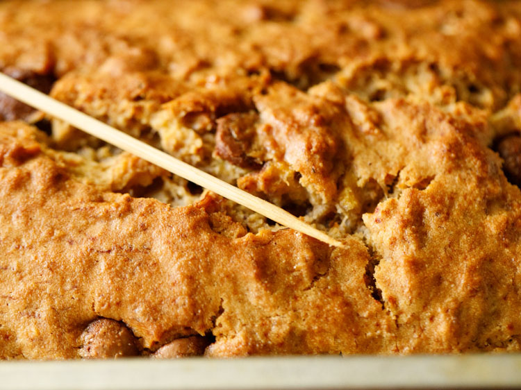 checking doneness of the bread with a bamboo skewer. 