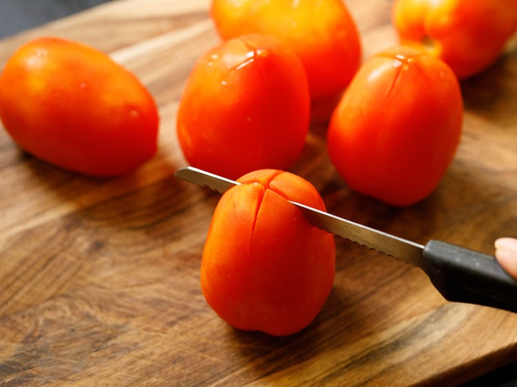 giving criss cross slits on the base of the tomatoes.