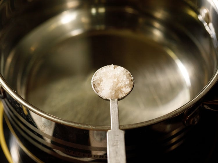 salt being added to water in the pan.