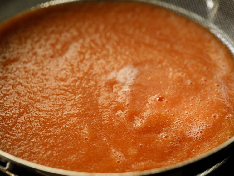 tomato puree being strained.
