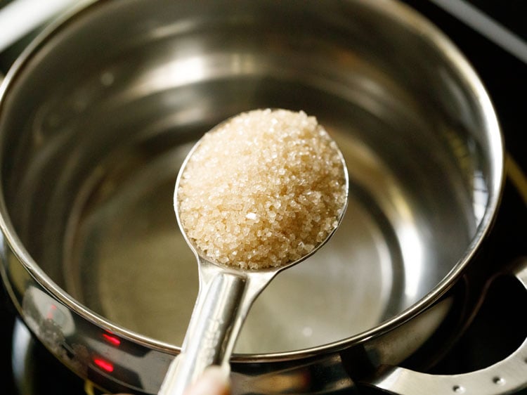 Adding unrefined raw sugar to water.