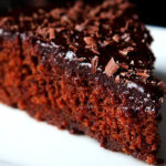closeup shot of a triangular wedge of eggless chocolate cake on a white plate