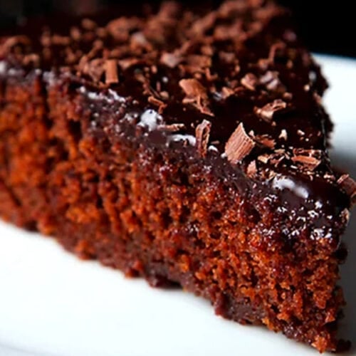 closeup shot of a triangular wedge of eggless chocolate cake on a white plate  chocolate banana carrot cake eggless chocolate cake 2 500x500