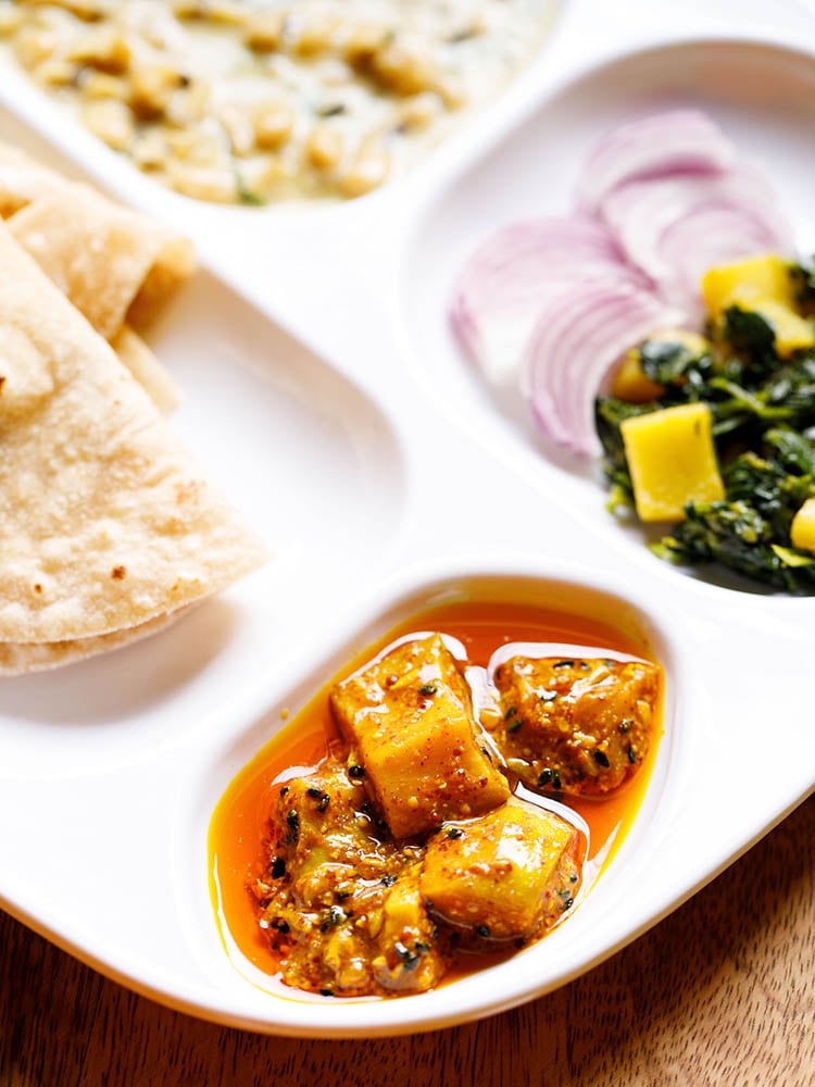 punjabi mango pickle served as a part of an indian meal in a white plate