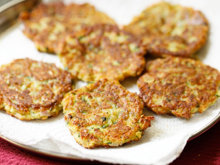 fried crispy zucchini fritters kept in kitchen paper towels