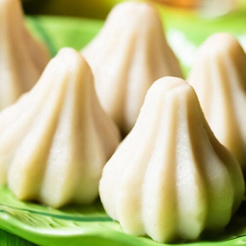 modak arranged beautifully on a bright green plate.