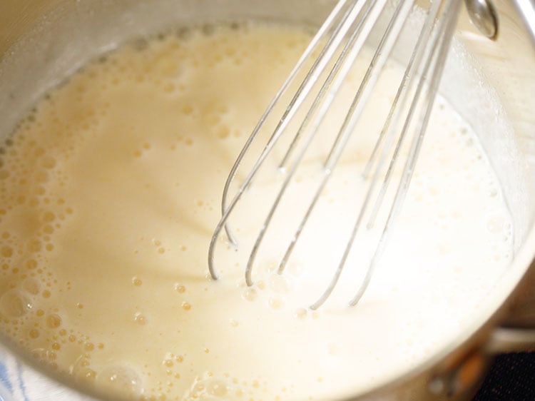 curd being whisked with water and turmeric to make buttermilk for kerala moru curry