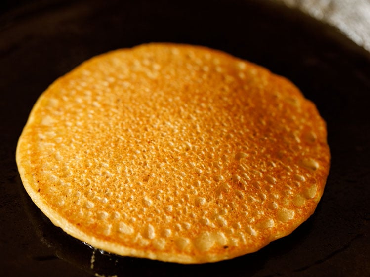 pumpkin pancake flipped and second side being cooked.