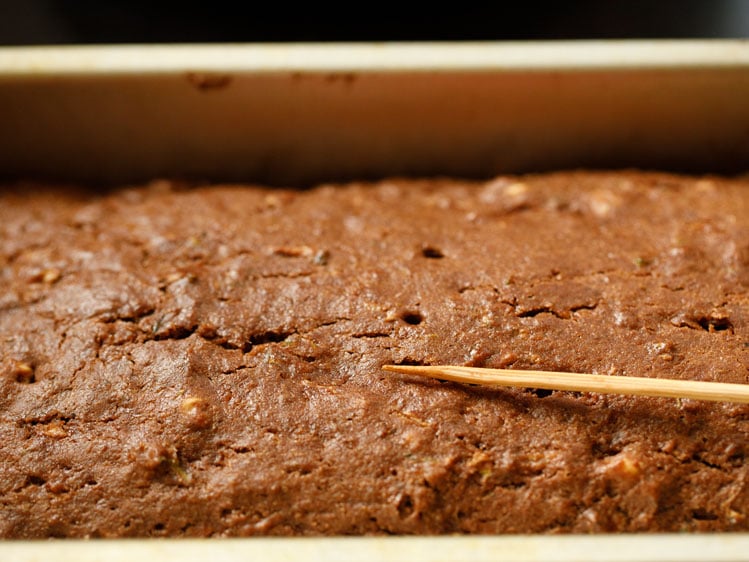 checking doneness of zucchini bread with a bamboo skewer