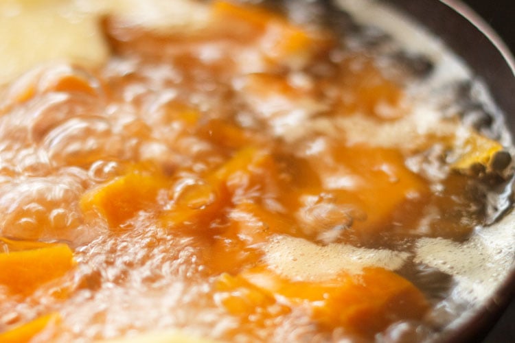 simmering pot of water and pumpkin cubes